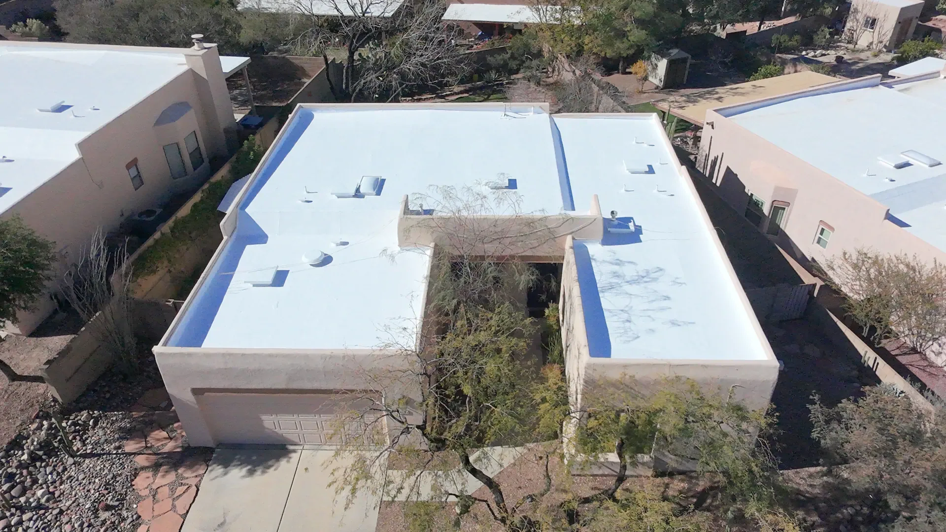 A white coated flat roof on a stucco home in Tucson